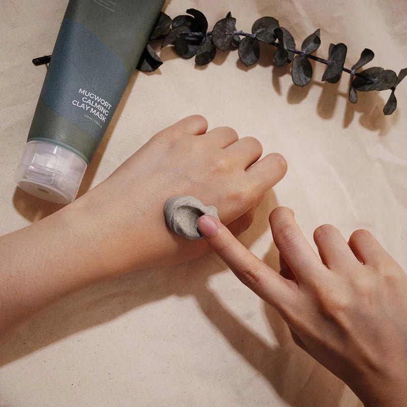 Isntree Real Mugwort Clay Mask being gently massaged onto skin, soothing and exfoliating while cleaning pores