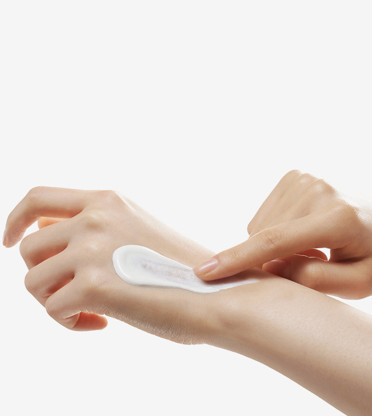 Some By Mi Truecica Mineral 100 Calming Suncream – Applying sunscreen to face and neck, gently patting it into the skin for a smooth, even finish while providing hydration and protection.