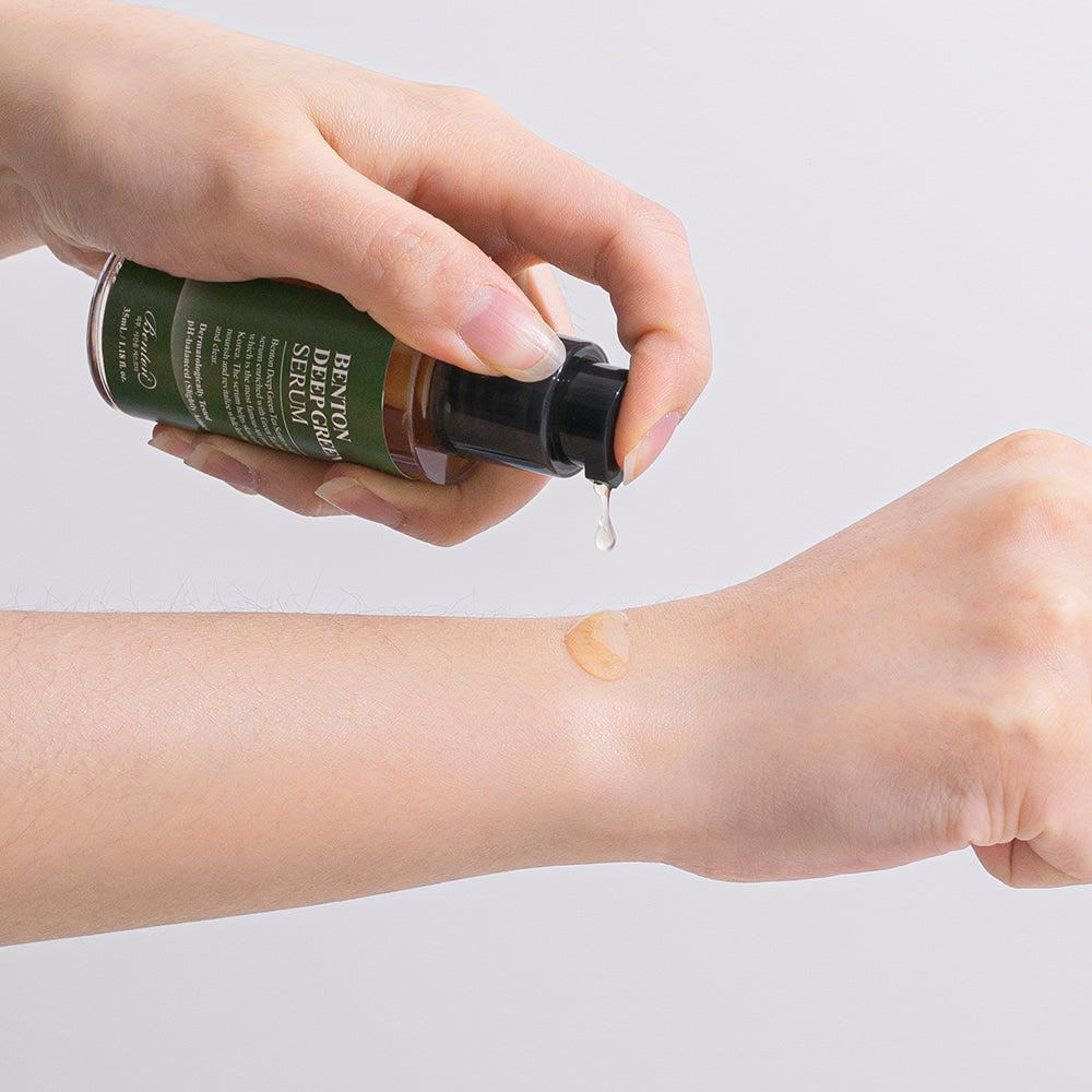 Person applying Benton Deep Green Tea Serum to their face, demonstrating how the serum hydrates and calms irritated skin while balancing oil