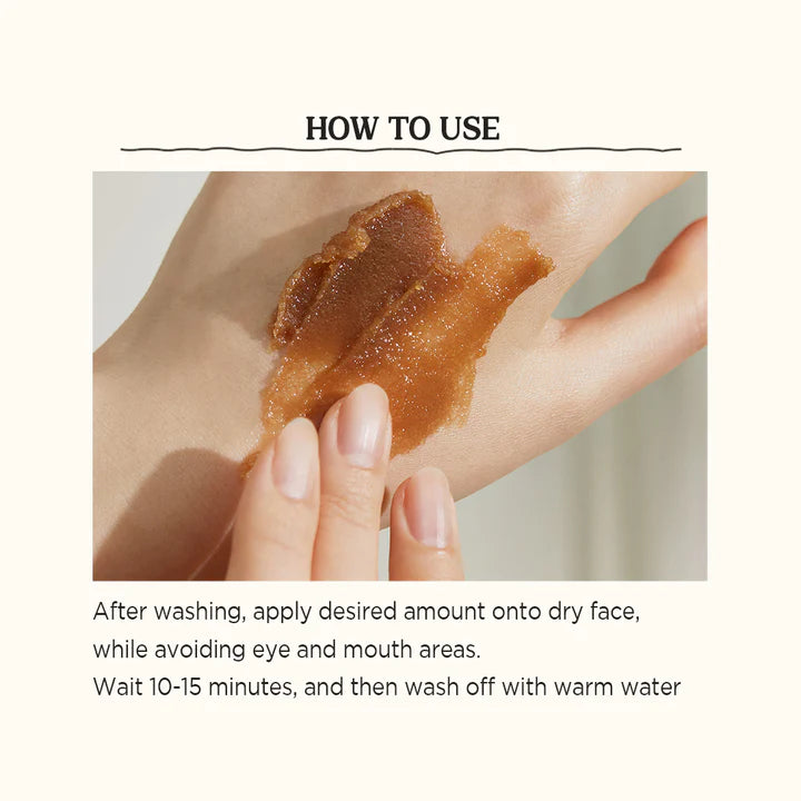 Applying Skinfood Black Sugar Mask Wash Off – Gently massaging the mask in circular motions on damp skin for exfoliation and hydration.