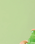 Person spraying Nature Republic Aloe Vera Soothing Gel Mist on the face, showing a refreshing burst of mist being applied gently to the skin.