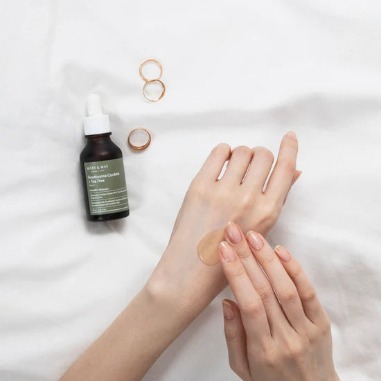 Applying Mary & May Houttuynia Cordata Tea Tree Serum – Gently massaging a few drops of the serum onto the face, showing its smooth texture and fast absorption.