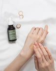 Applying Mary & May Houttuynia Cordata Tea Tree Serum – Gently massaging a few drops of the serum onto the face, showing its smooth texture and fast absorption.