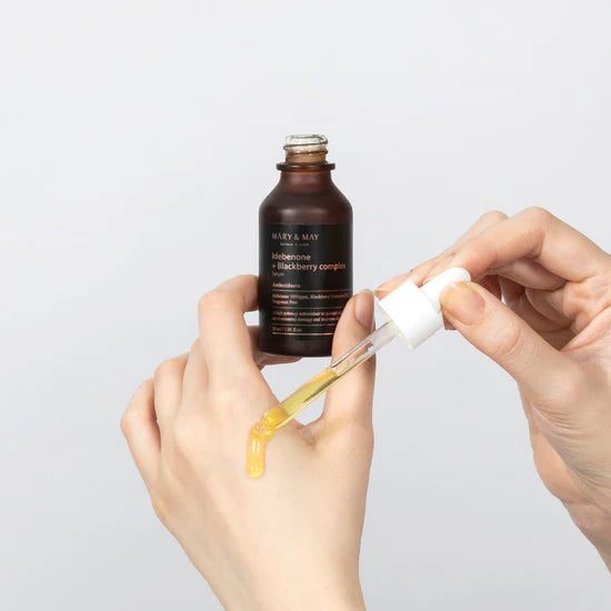Applying Mary & May Idebenone Blackberry Complex Serum – Gently massaging the serum onto the face and neck, highlighting its lightweight texture and quick absorption.