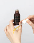 Applying Mary & May Idebenone Blackberry Complex Serum – Gently massaging the serum onto the face and neck, highlighting its lightweight texture and quick absorption.
