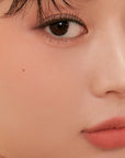 Close-up of the Peripera Pure Blushed Sunshine Cheek blush on the cheeks, highlighting the smooth, seamless application, and the radiant, matte finish that absorbs excess oil for long-lasting wear.