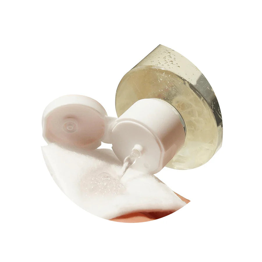 Close-up of the cleansing water being dispensed onto a cotton pad, demonstrating its lightweight, clear formula that hydrates while effectively removing makeup and impurities.