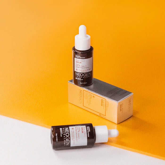 Flat lay of the serum bottle, surrounded by citrus fruits and ingredients like vitamin E and hyaluronic acid, illustrating the nourishing, antioxidant-rich formulation.