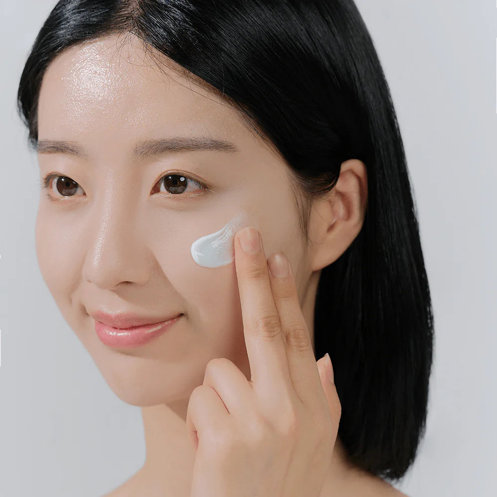 Applying Skin1004 Hyalu-Cica Water-Fit Sun Serum – Evenly applying serum to face, neck, and arms for sun protection and hydration.