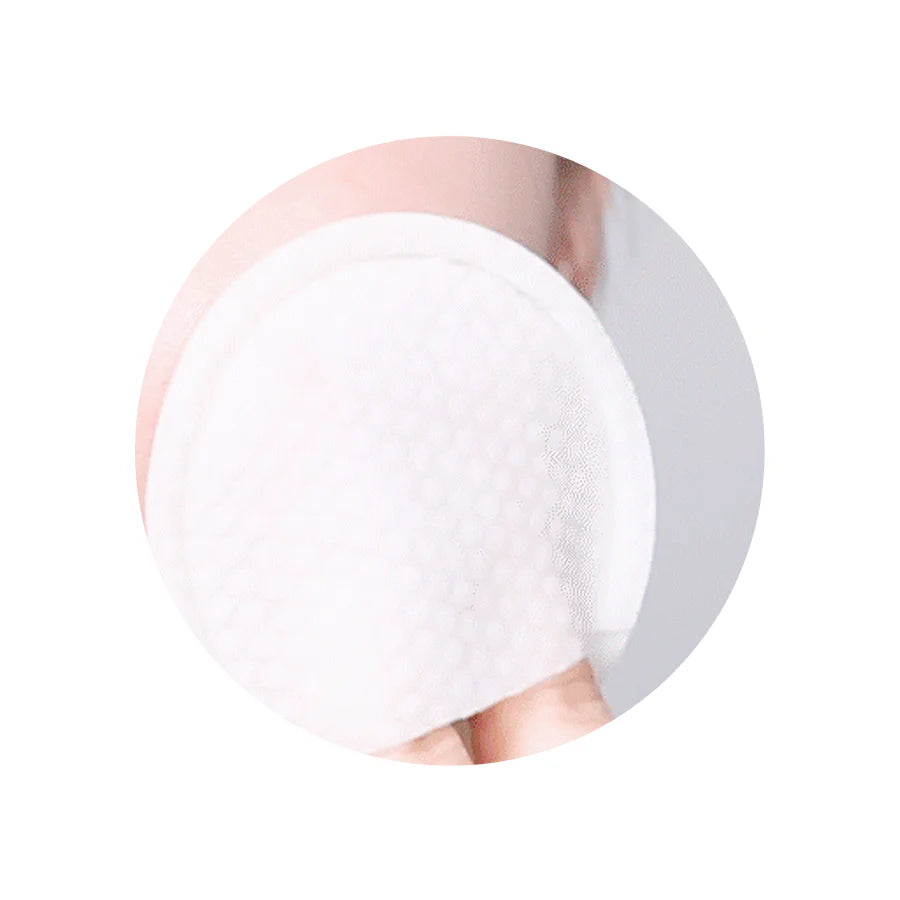 Image of a person using a cotton gauze pad to gently exfoliate their face, showing the two sides of the pad – the gauze peeling side and embossed side – in action.
